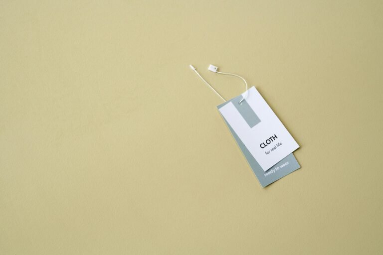 Cloth brand clothing tag displayed on a soft beige background, featuring the text "CLOTH for real life" and "ready to wear," highlighting its stylish and practical design.